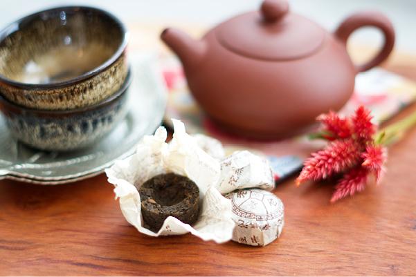 2012 menghai nests of pu erh in front of yixing pot and small tea cups
