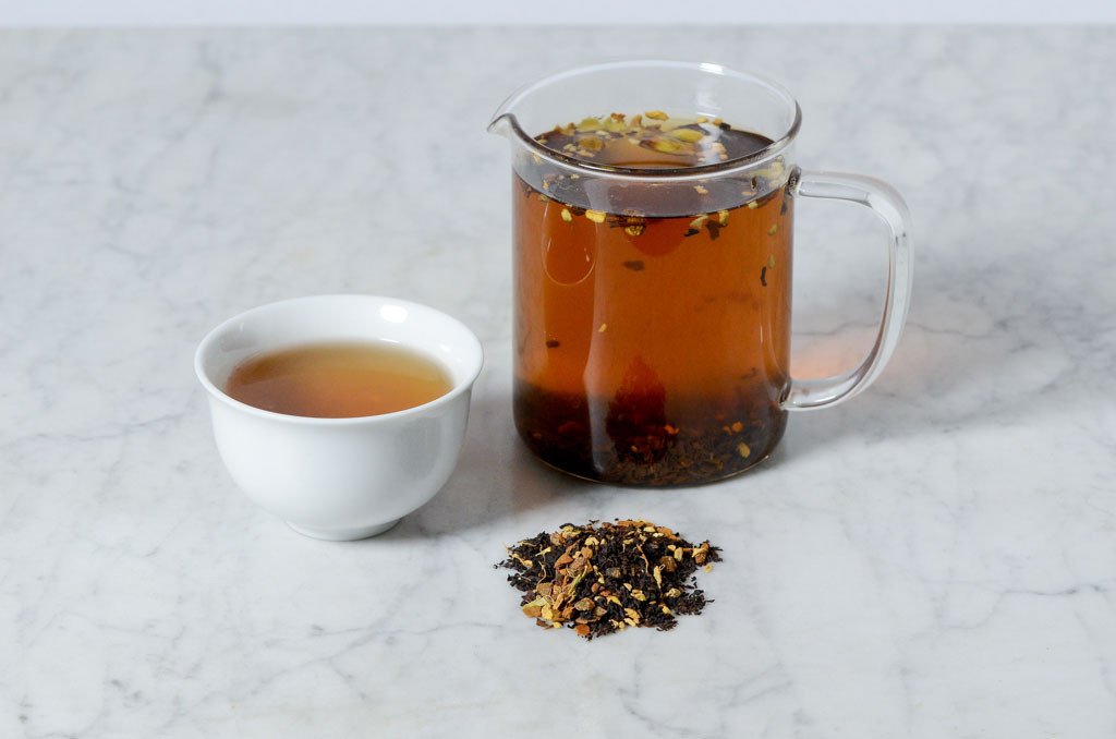 loose leaf pumpkin spice chai tea infused in a glass infuser and white cup