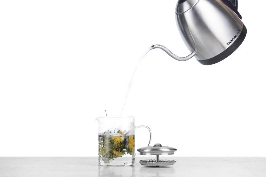 Bonavita kettle pouring water into a glass infuser with tranquilite full flower herbal tisane