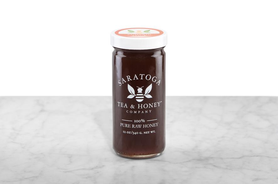 Dark amber Pumpkin Spice Honey displayed in a 12oz cylindrical glass jar with a white lid. The logo and the words: "100% Pure Raw Honey" are printed on the jar.