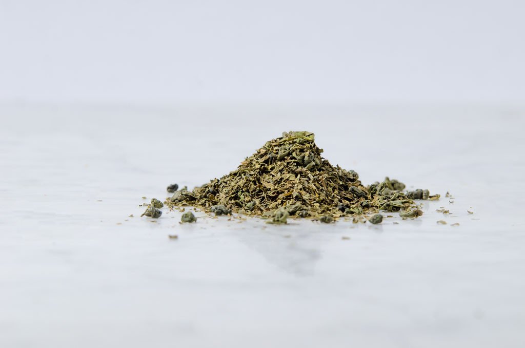 loose leaf mint green tea leaves on a marble background