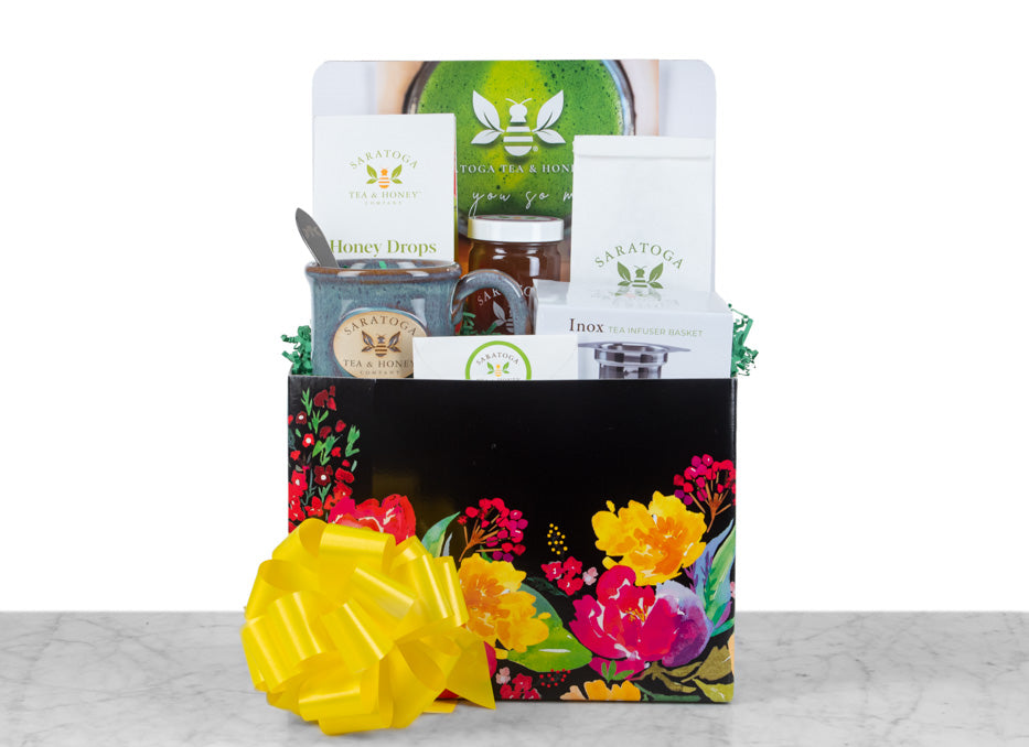 large tea and honey gift basket in floral motif basket with saratoga tea and honey branded mug, honey candy, tea, tea infuser, and honey