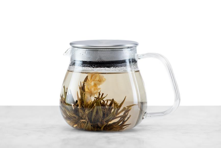 Jasmine Flower Craft blooming tea fully brewed and open in a glass teapot. 