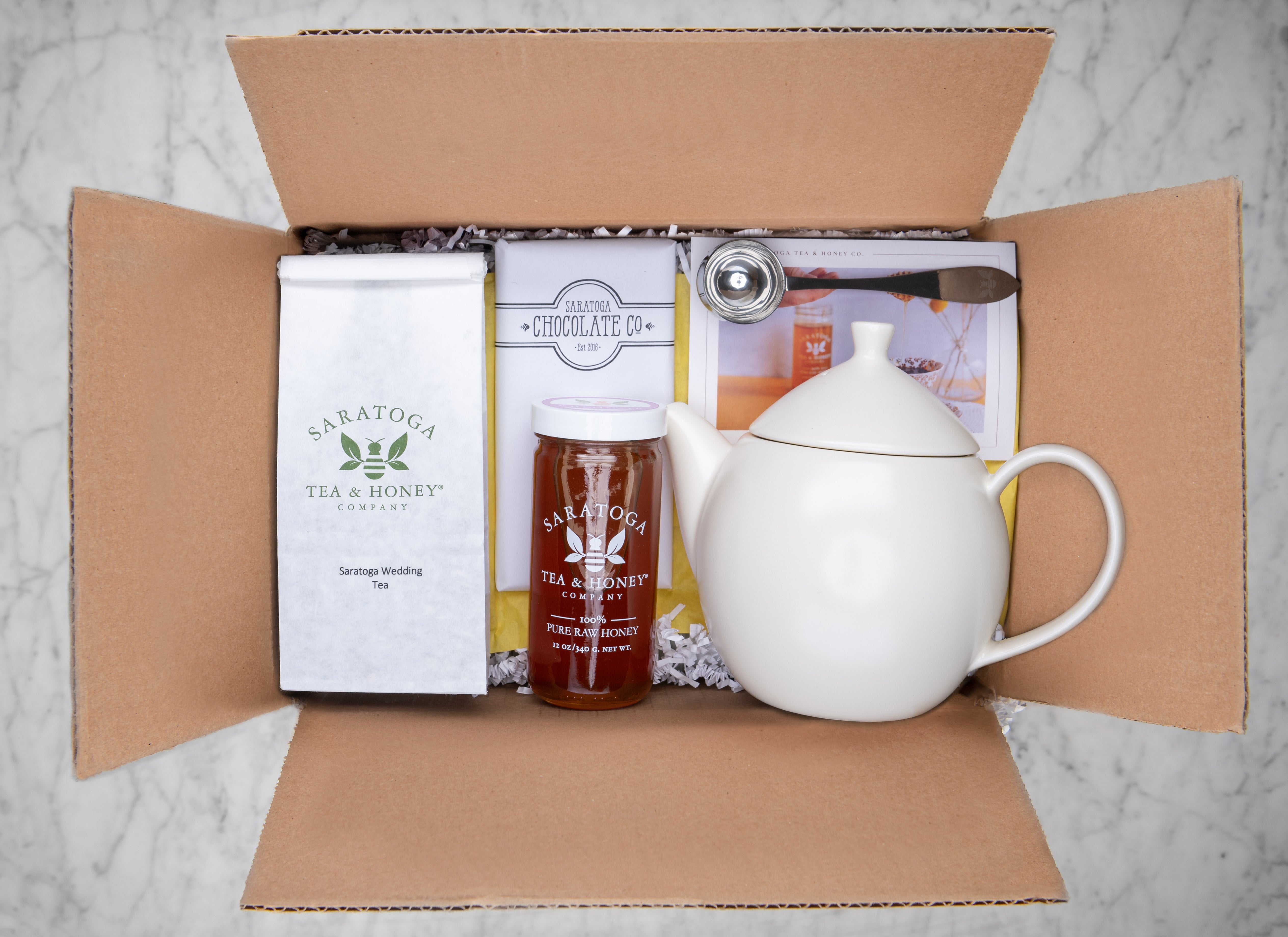 tea gift set for couples with large tea pot, loose tea, tea scoop, jar of honey and a chocolate bar feat Saratoga Wedding Tea