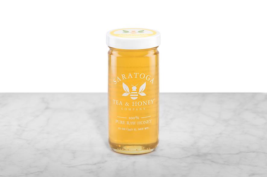 Golden-yellow Ukrainian Sunflower Honey displayed in a 12oz cylindrical glass jar with a white lid. The logo and the words: "100% Pure Raw Honey" are printed on the jar.