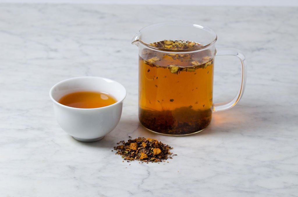 Mint Chocolate tea brewed and displayed in a white cup and glass infuser