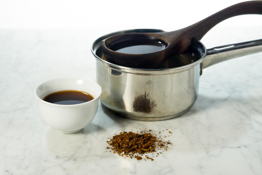 Chaga brewed in a saucepot and served into a white cup with a wooden ladle