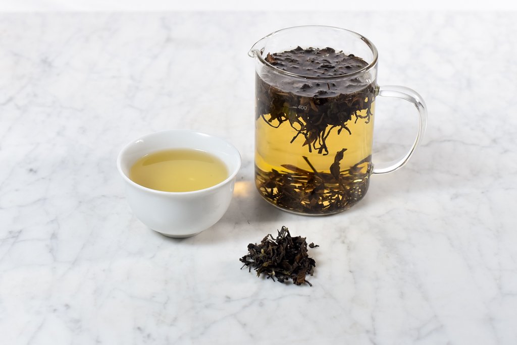Bai Hao Jingmai "Oriental Beauty" Oolong loose leaf tea brewed in a glass infuser and white cup