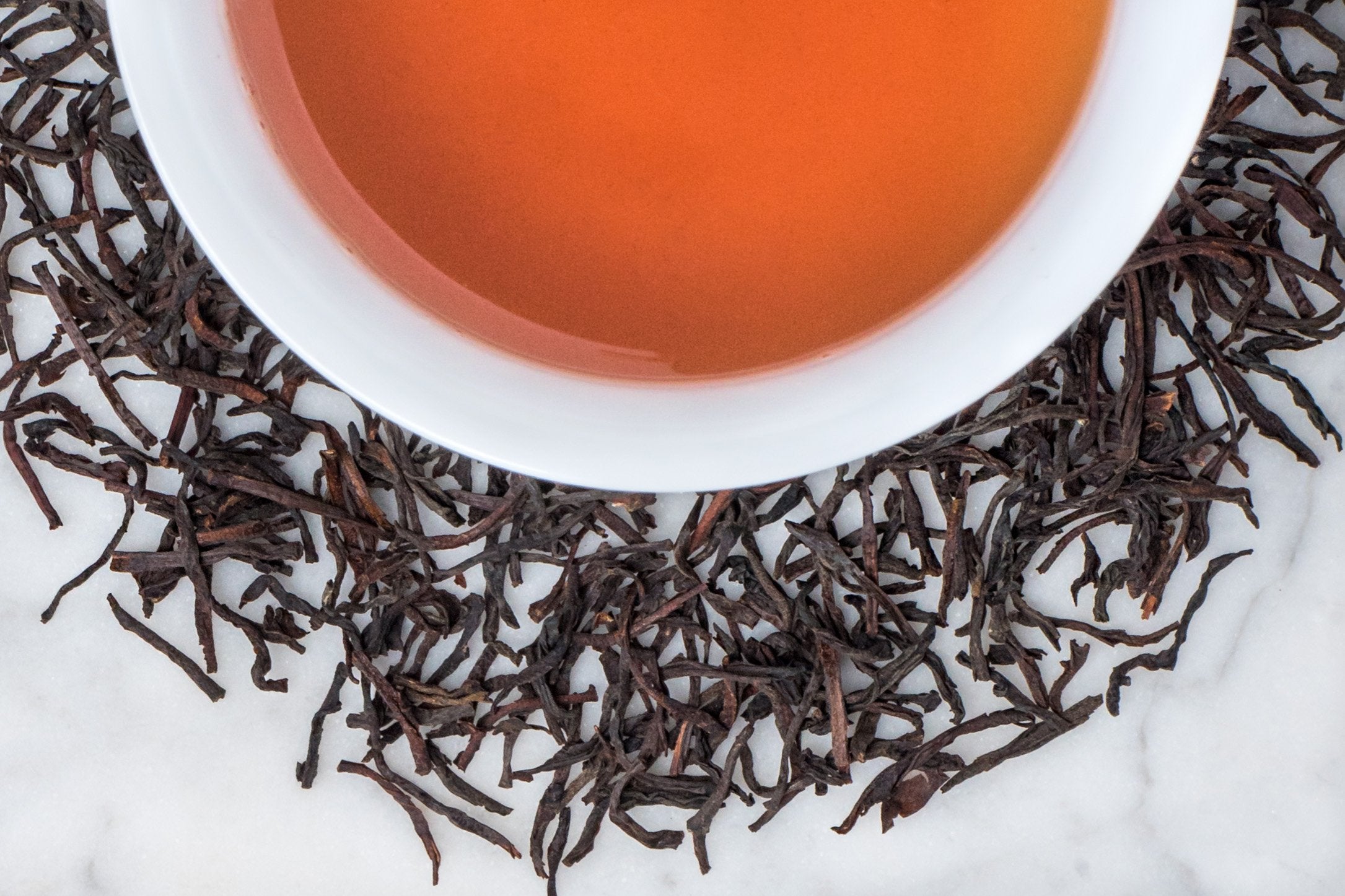 Ceylon Orange Pekoe Whole Beautiful Long Leaves and Cup Of Burnt Orange Tea Liquor