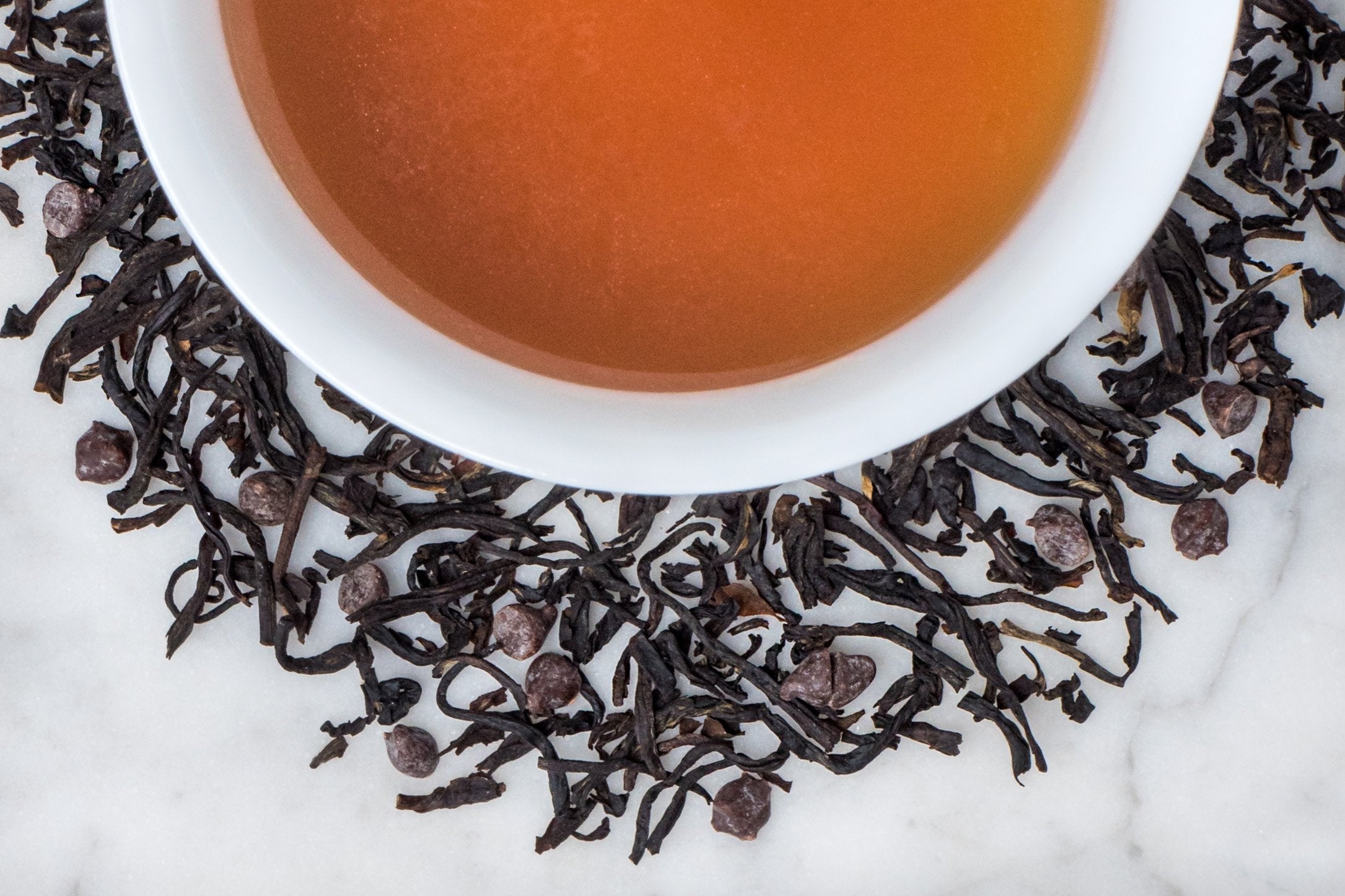Long Luxurious Black Tea Leaves and Tiny Pieces of Dark French Chocolate Surrounding A Velvety Cup of Vanilla Bean and Chocolate Scented Tea