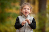 little girl in a vest eating a wildflower honey straw