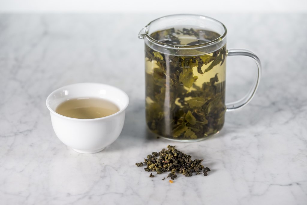 stone fruit oolong brewed in a glass infuser and white cup