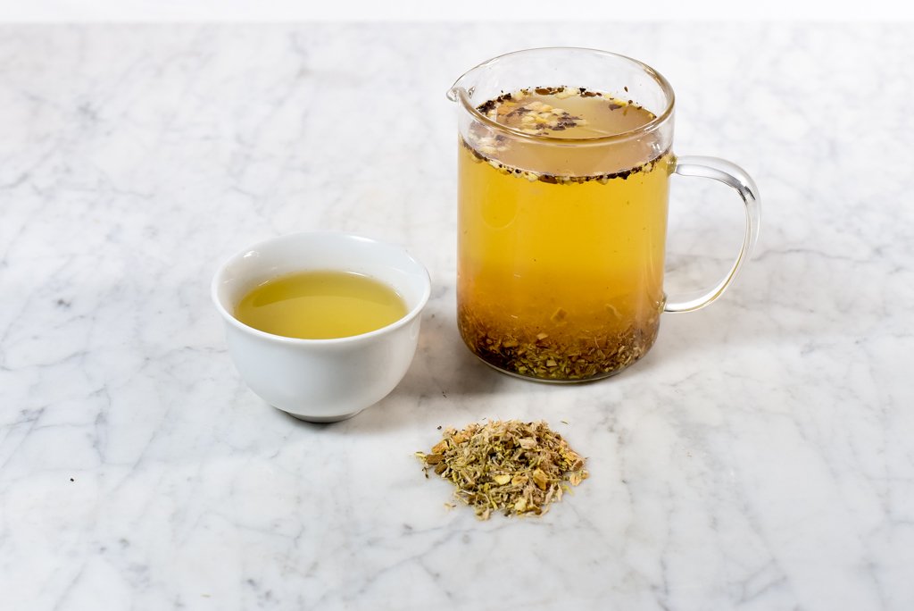 songbird throat coat tea in a white cup and glass infuser