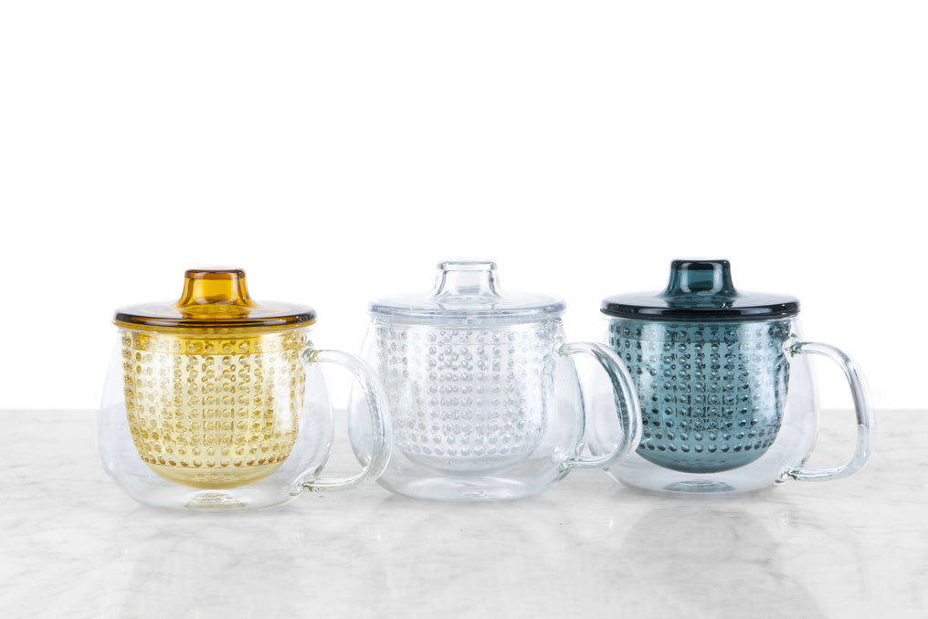 mod-style, brew-in tea mugs picturing three colors left to right: yellow, clear, blue